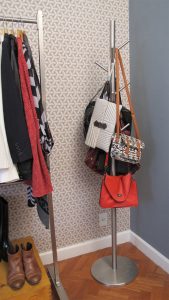 Cabideiro com bolsas no quarto moderno ao lado de uma arara de aço inox