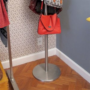 Detalhe da base do cabideiro em aço inox Alezzia no piso do quarto