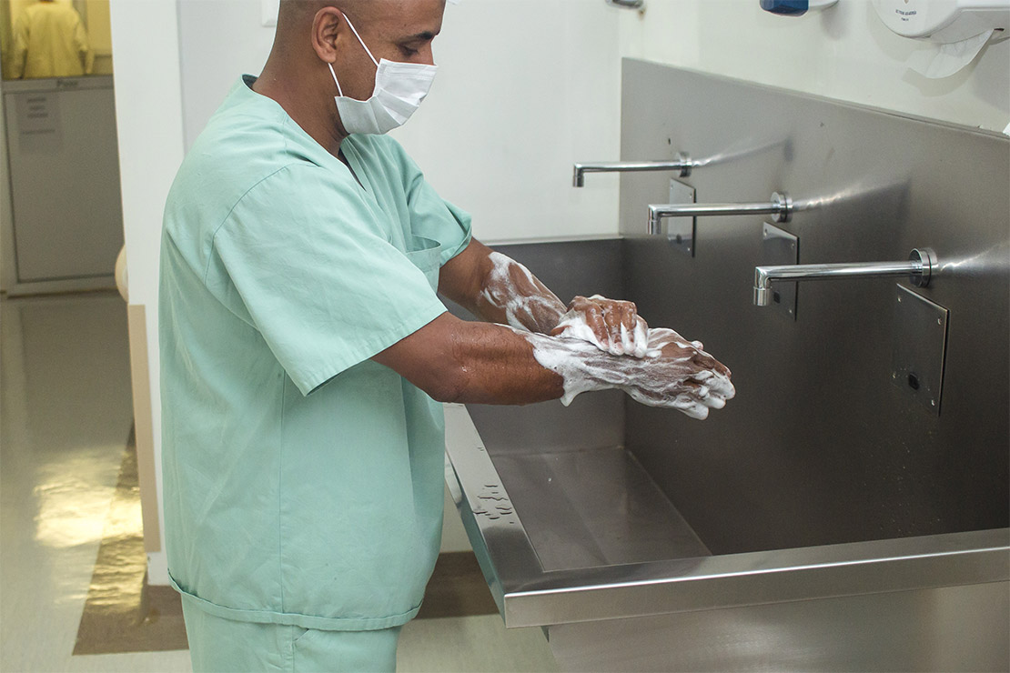 profissional de saude lavando as maos em lavatorio cirurgico de aço inox