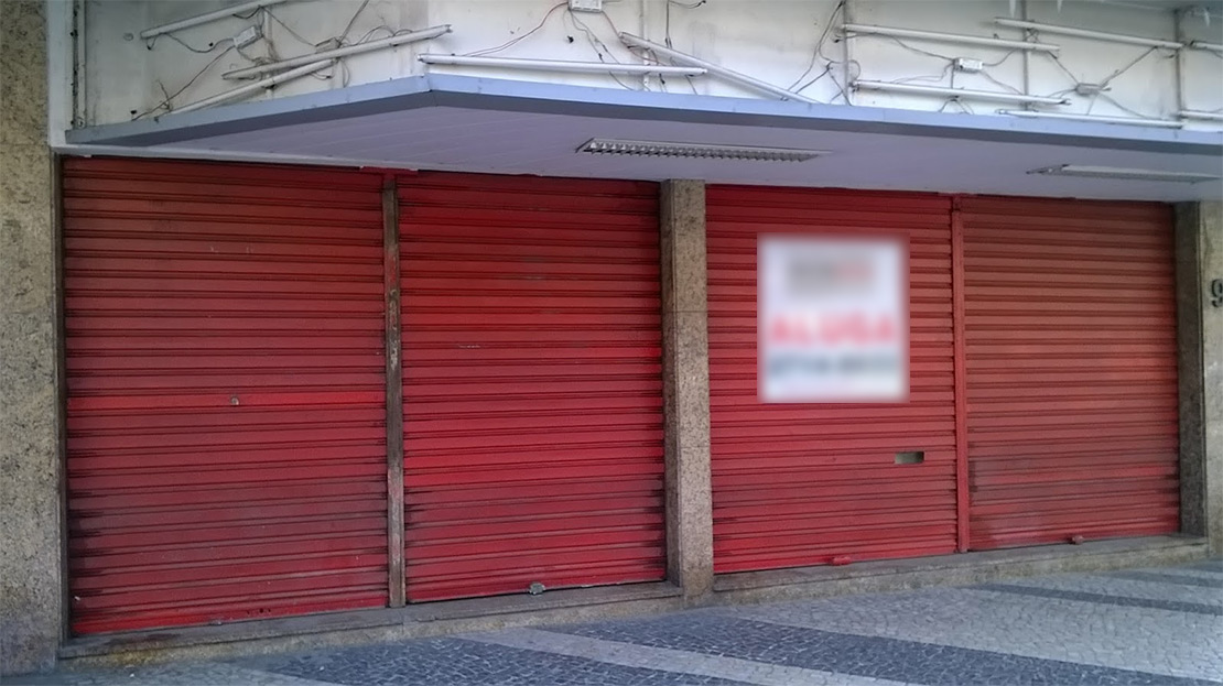 Loja fechada com portas vermelhas para alugar