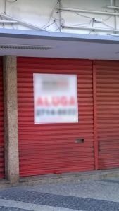 Loja fechada com portas vermelhas para alugar