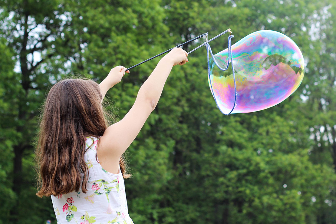 menina brincando com uma bolha de sabao