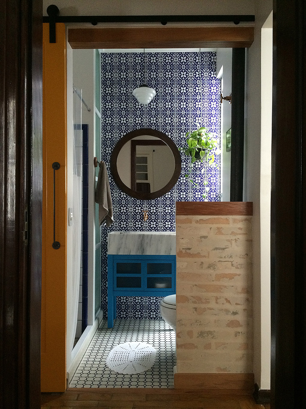 Retrofit de banheiro retro - Espelho redondo, meia parede, cuba de mármore, azulejo azul, porta de madeira