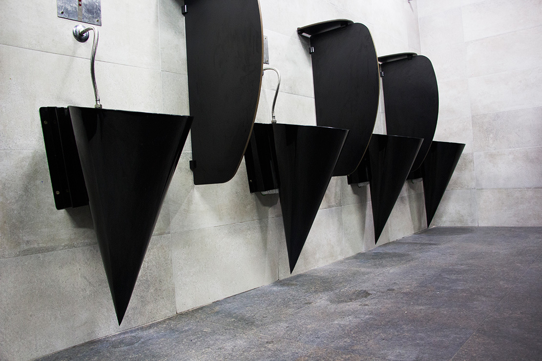 Mictornio moderno e criativo com pintura preta no banheiro da academia