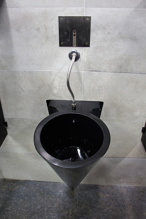mictorios modernos na cor preta em aço inox no banheiro da academia vistos de cima com o sistema hidráulico com sensor automático