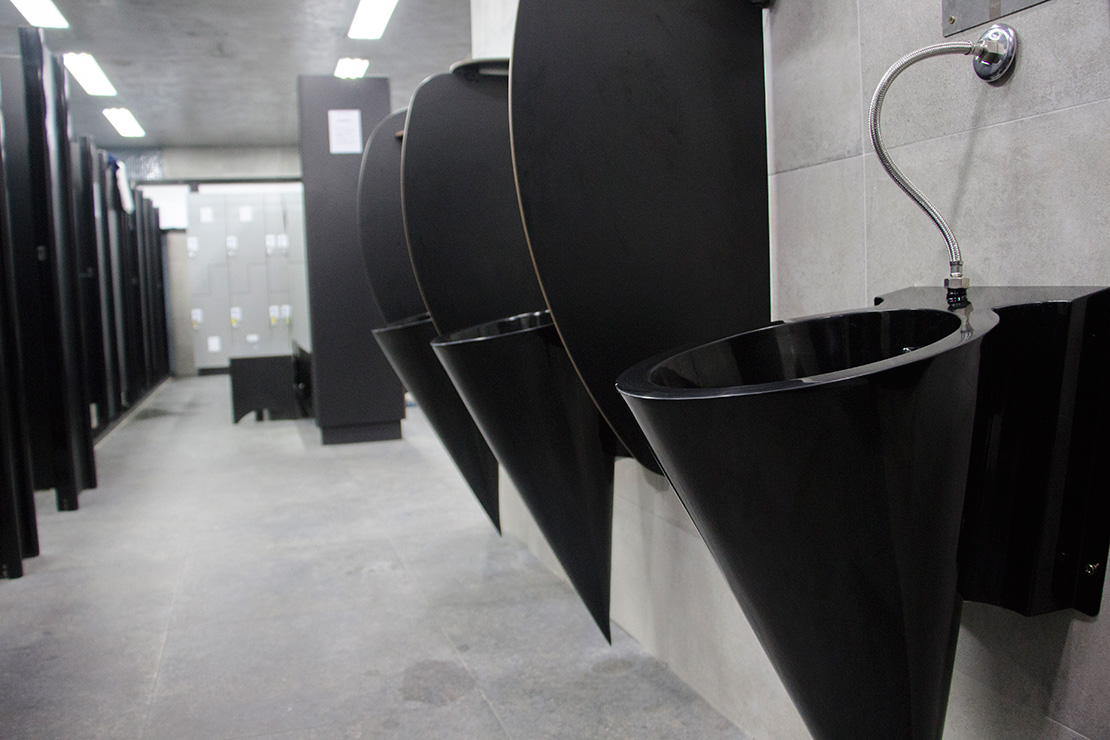 modernos mictorios conicos em aço inox pintados de preto com pintura automotiva no banheiro da academia