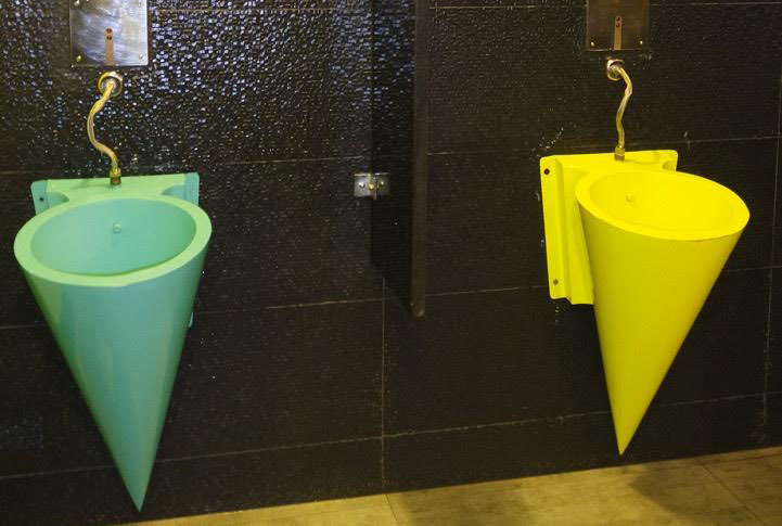 mictórios criativos coloridos com parede preta no banheiro do boliche